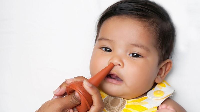 Hình ảnh một người đang nhỏ thuốc hoặc nước muối vào mắt một cách cẩn thận, sau khi đã vệ sinh tay sạch sẽ