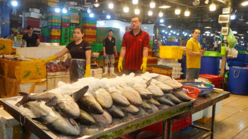 Cảnh mua bán nhộn nhịp tại khu vực thủy sản tươi sống ở chợ Bình Điền, nguồn nguyên liệu dồi dào cho gia công thực phẩm bảo vệ sức khỏe.